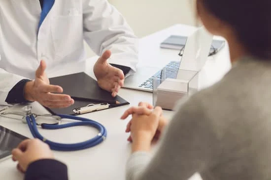 Confident Doctor and Couple Patient Sitting at the Table in Clinic Office. Family Doctor.